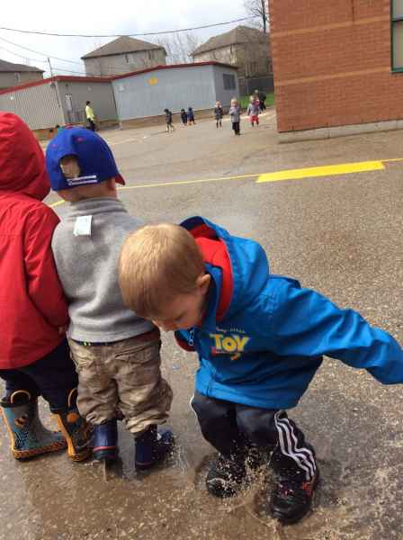 boy jumping in a water puddle